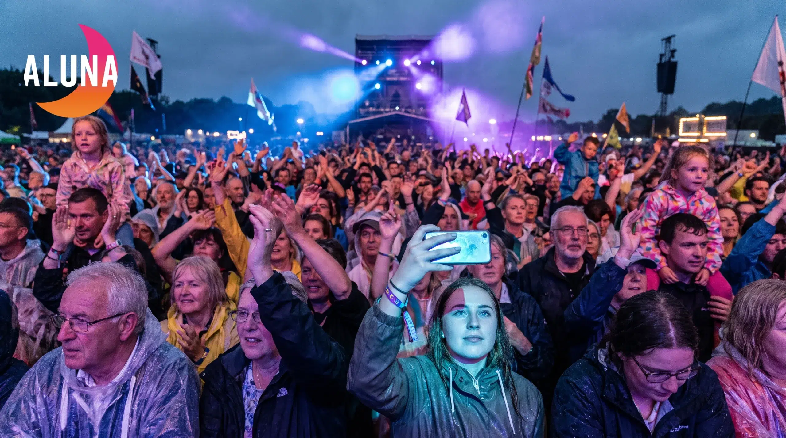Public en effervescence devant la scène du festival rap ardèche Aluna sous des lumières colorées.